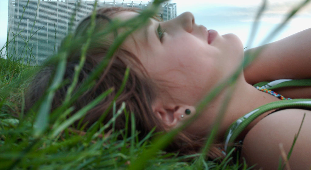 Frau die im Gras liegt und entspannt